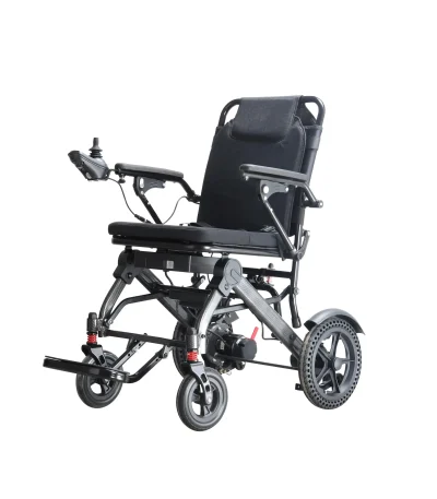 A modern electric wheelchair with a black cushioned seat, armrests, and a joystick control on the left armrest. The wheelchair has large rear wheels with a unique tread pattern and smaller front wheels with suspension.