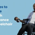 A person in a wheelchair performs a seated overhead press exercise with a resistance band, demonstrating strength and balance training.